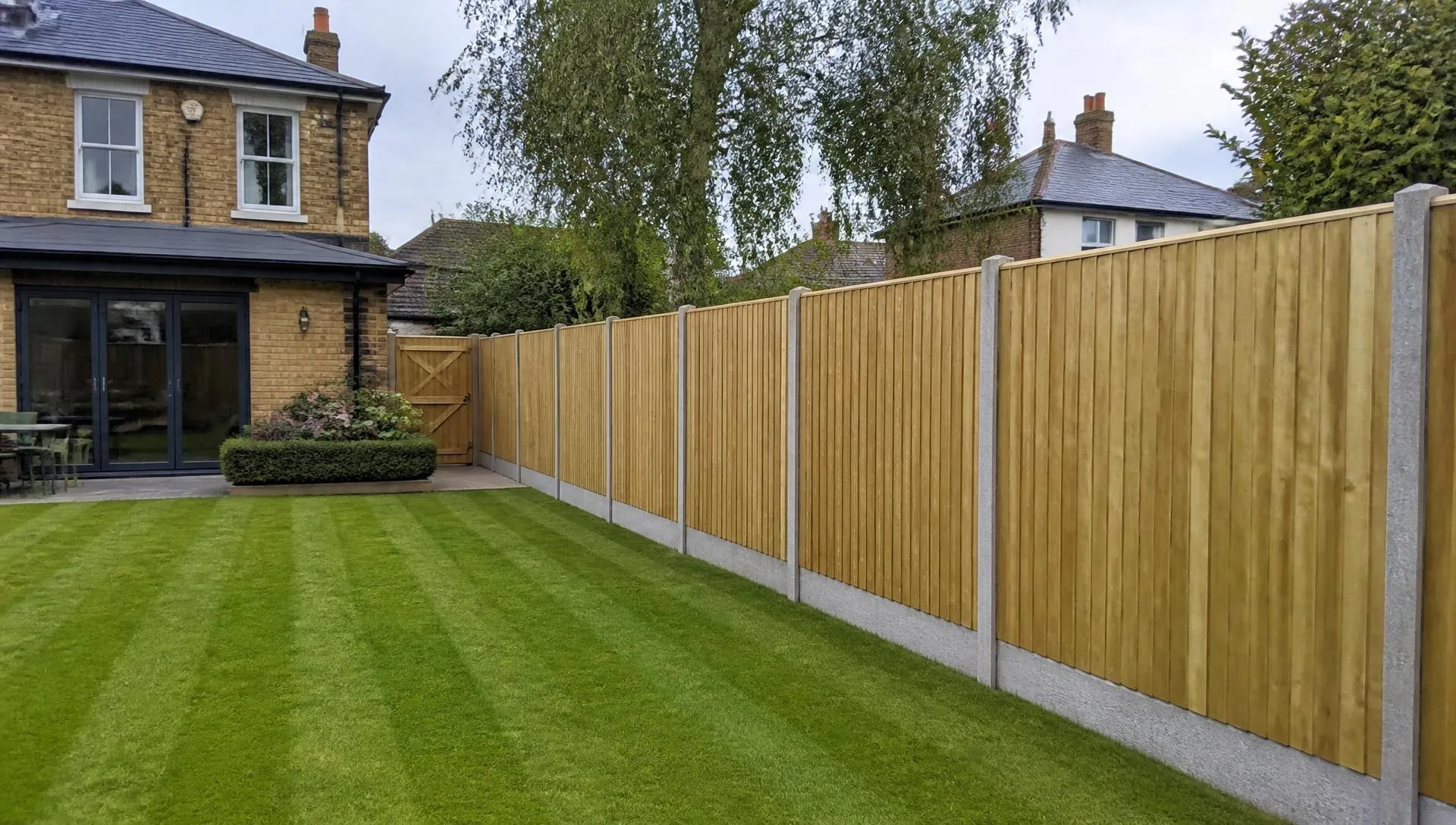 Newly installed close board timber fence with concrete posts along a South London back garden